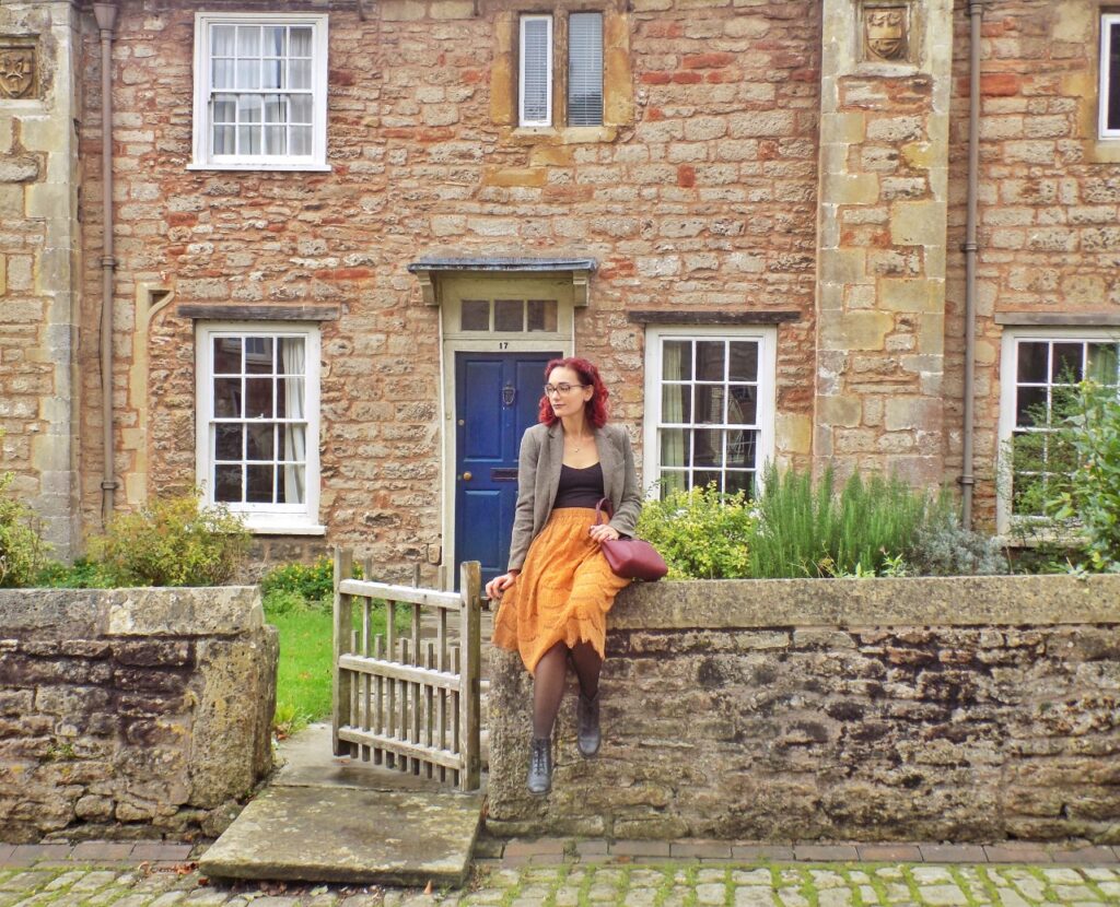 photo of a woman standing in front of a cottage in Wells, England