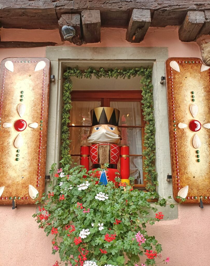 a nutcracker with a face mask on a christmas shop in a village in Alsace