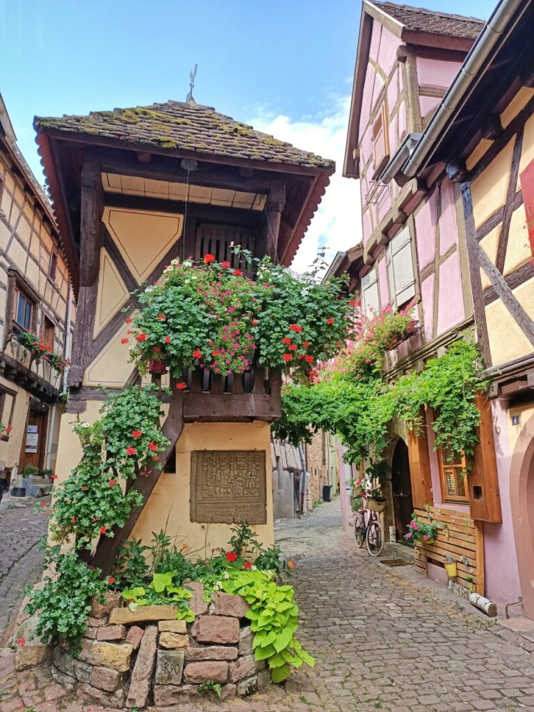 a medieval landmark in a medieval village with flowers and old houses