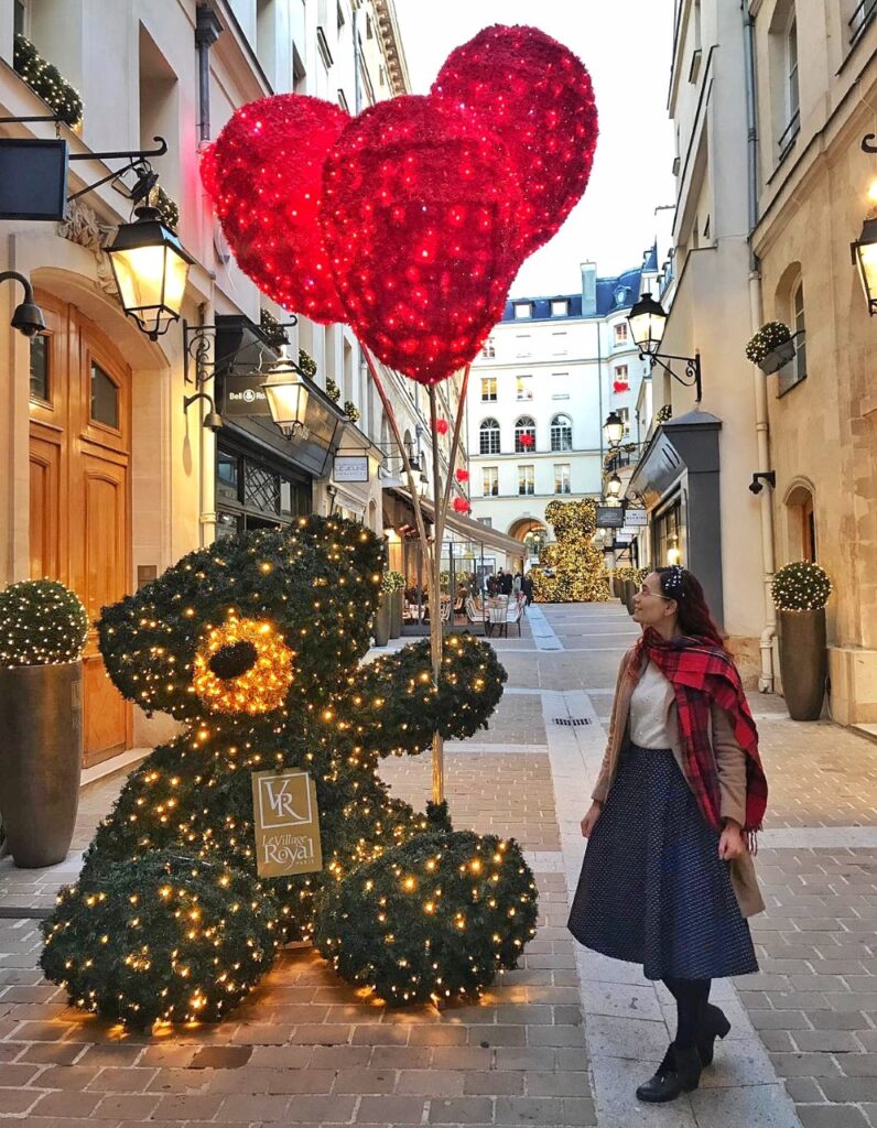 Village Royal In Paris, Christmas display in the shape of a big teddy bear with gold lights shining and big red balloons with sparkly lights.