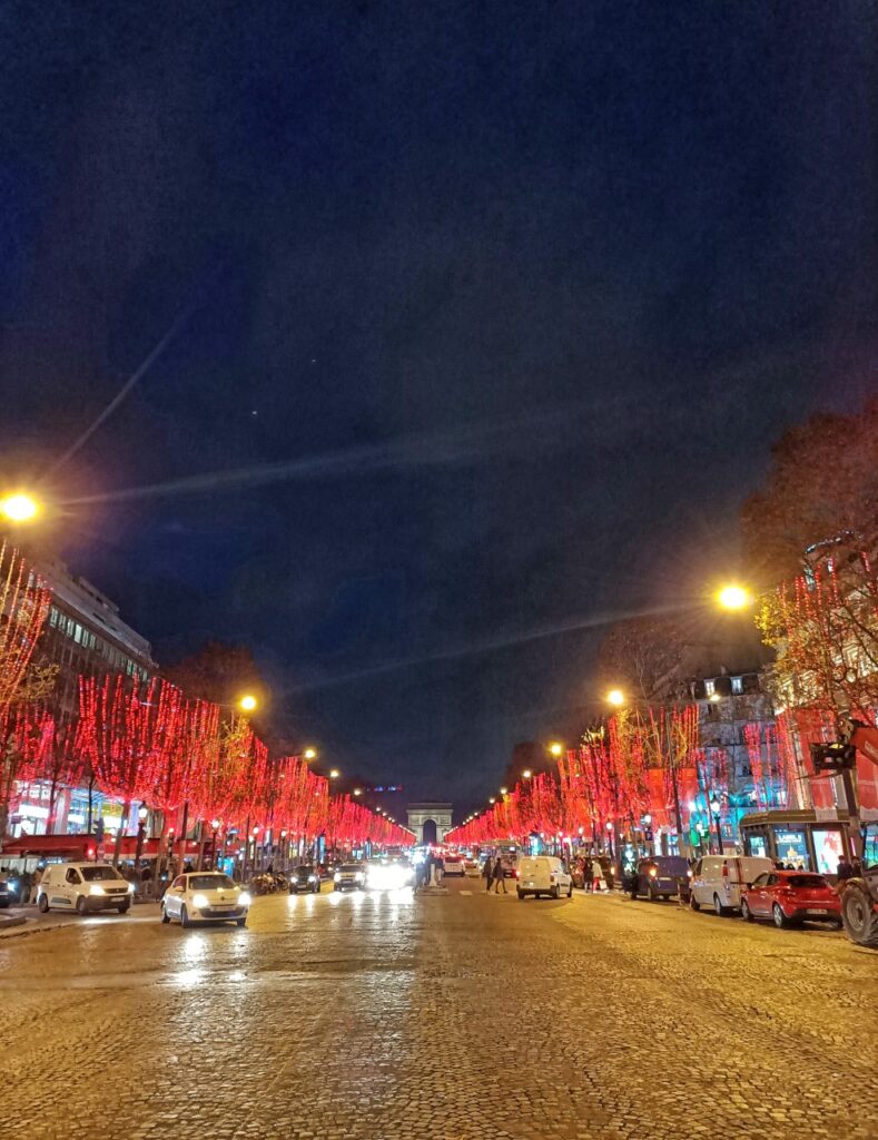 Champs Elysées in Paris with Christmas lights and Arch of Triumph in the background.
