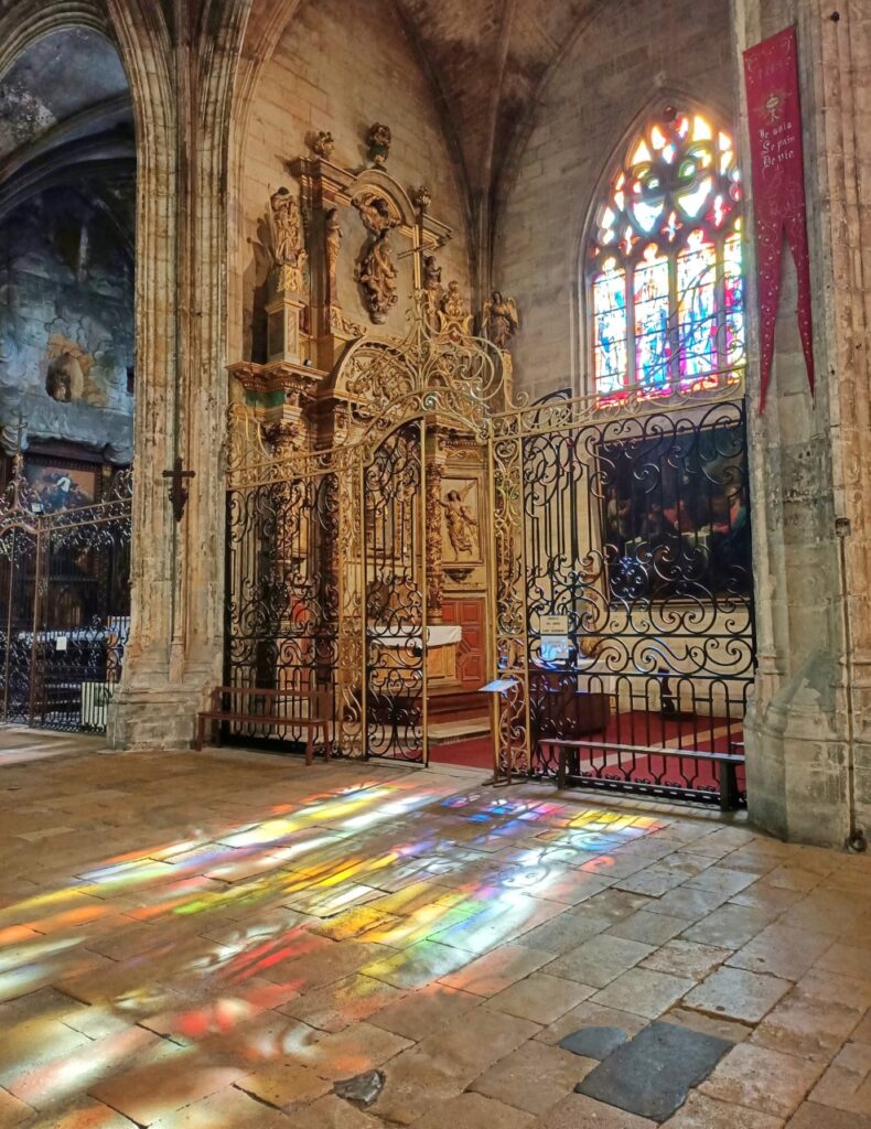 Inside of the Saint Michel Basilica in Bordeaux, France. The stained glass is reflected on the floor of the church.