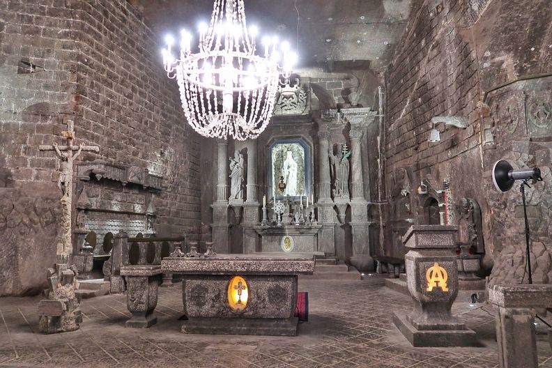 The St Kinga Chapel in the Wieliczka Salt Mine, near Krakow, Poland. The grey interiors of the chapel are made out of salt. The salt crystal chandelier is shining over the salt statues and altar.
